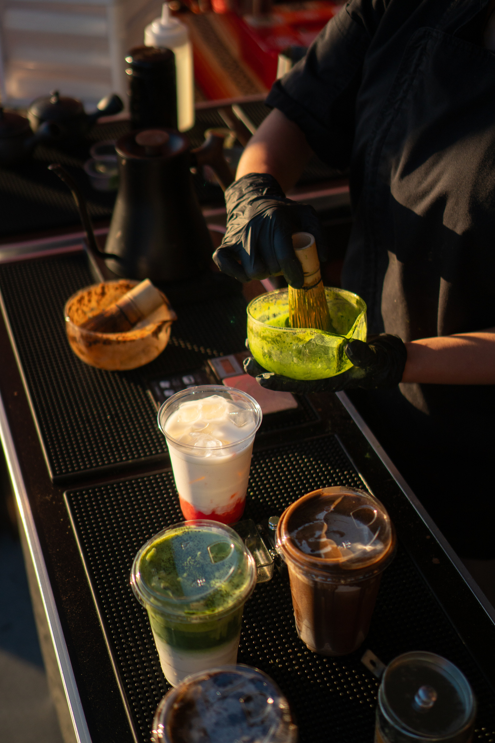 The Iro Tea bar mat with a matcha bowl and iced drinks before service