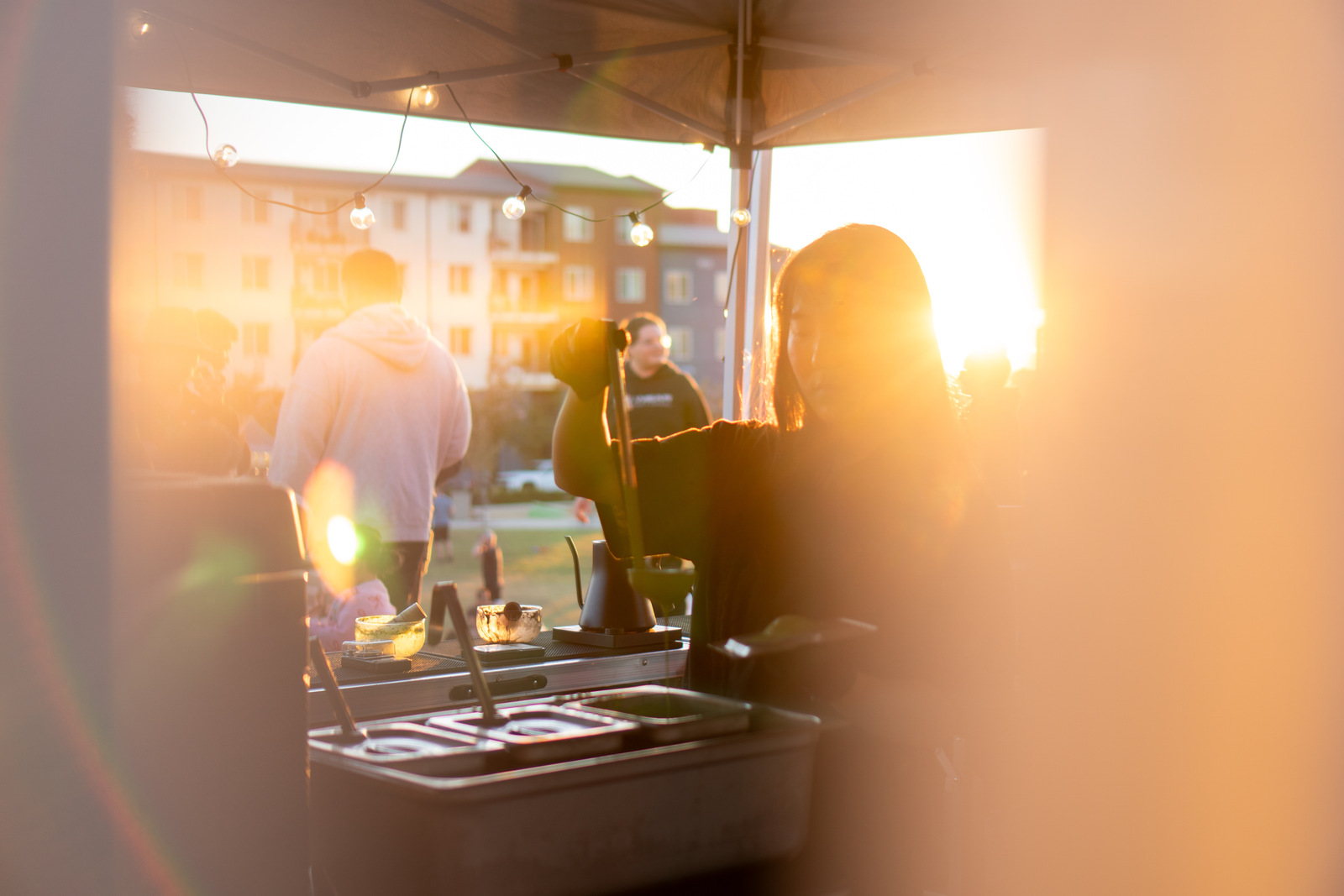 Silhouettes inside the Iro Tea market tent against a golden sunset