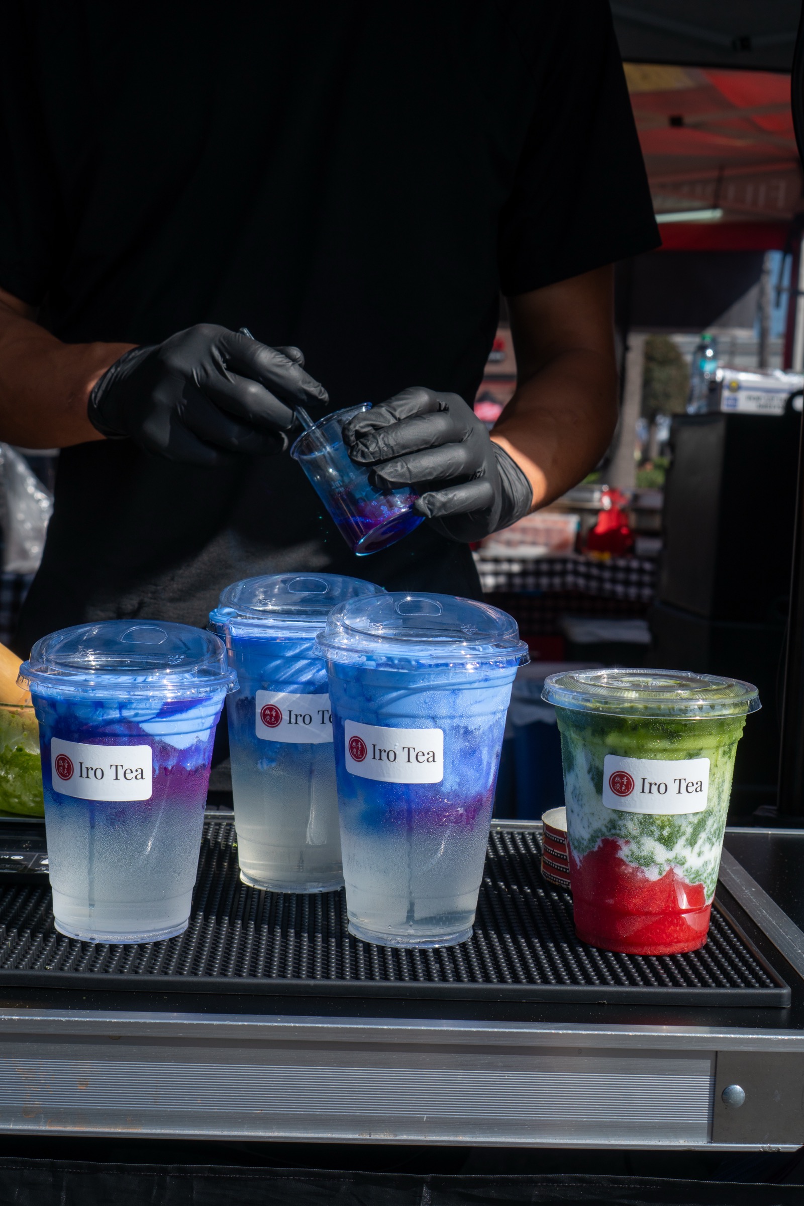Iro Tea — three coconut-spirulina einspänner and a strawberry matcha latte lined up at the market bar