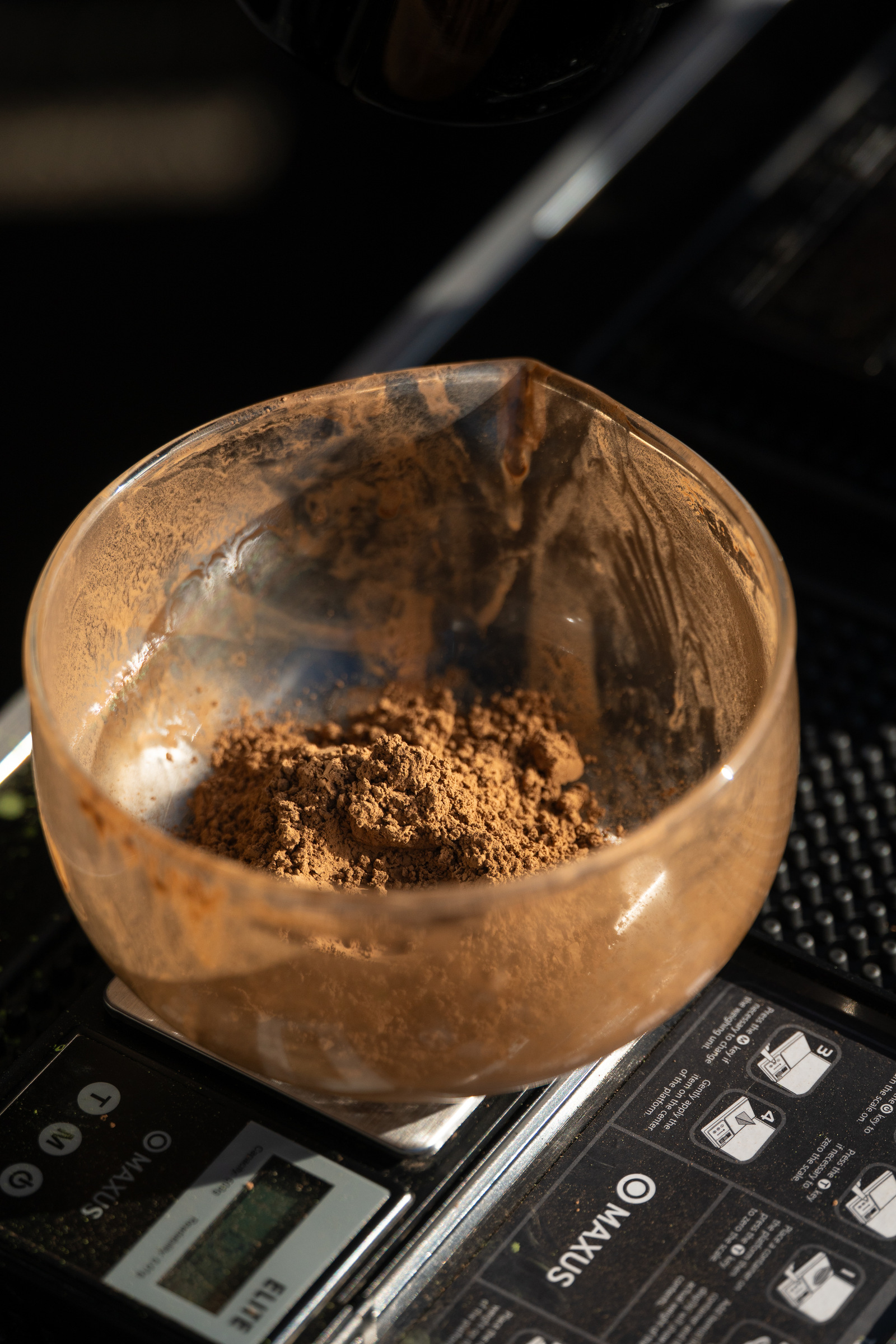 Roasted hojicha powder weighed in a glass bowl on a digital scale